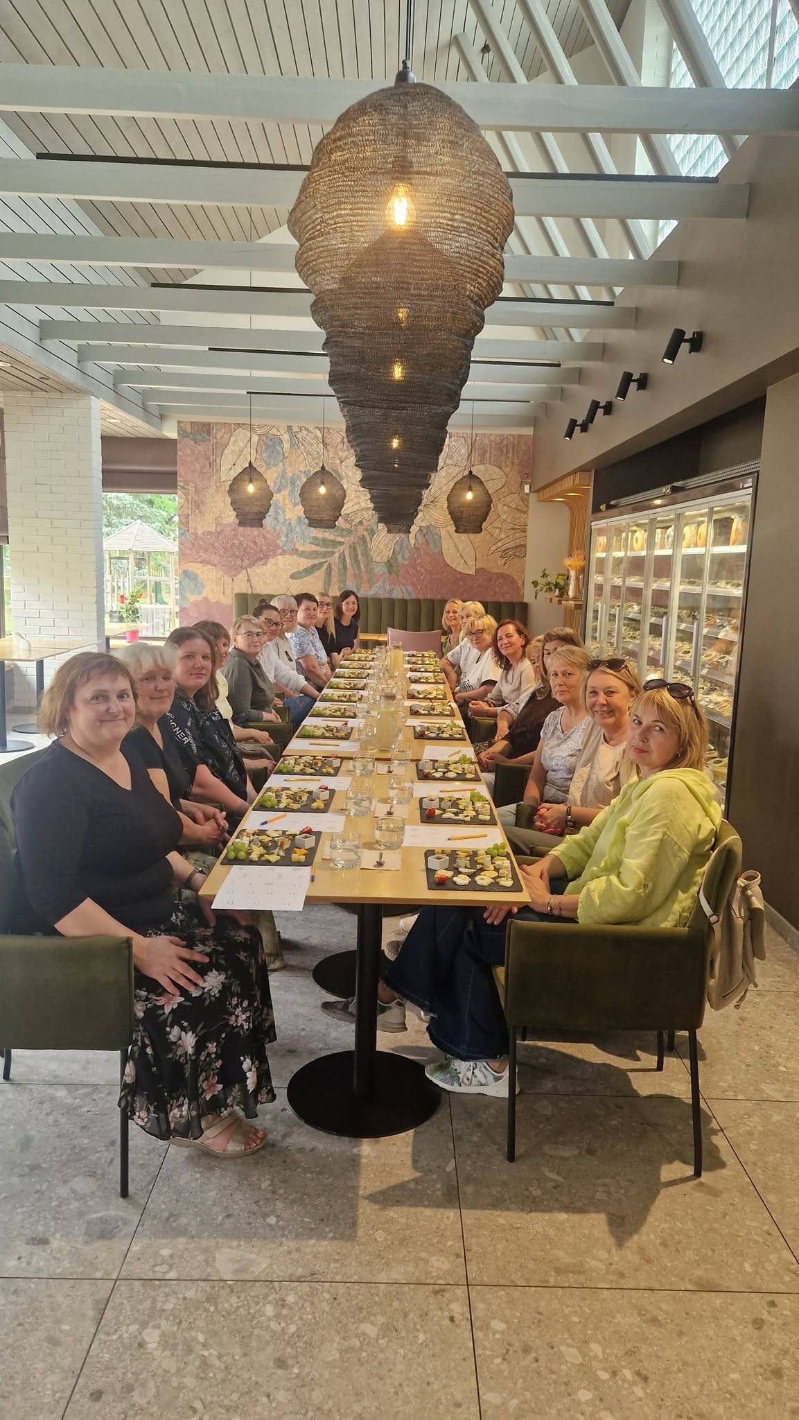 Grupė vasaros degustacijoje prie ilgo stalo